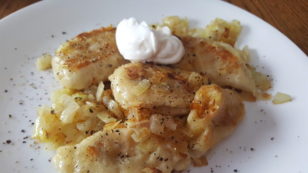 Pierogi served with sauteed onions and sour cream
