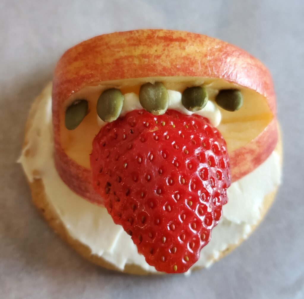 Apple mouth with pumpkin seed teeth and strawberry tongue