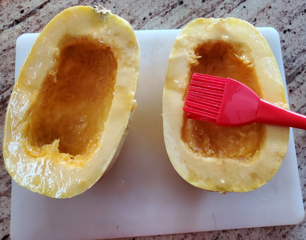 Spaghetti squash seeds removed adding olive oil