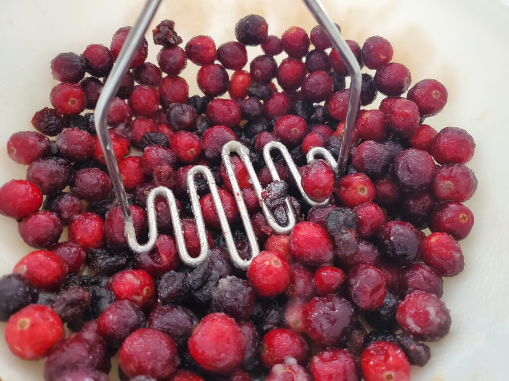 Mashing Cranberries with a potato masher